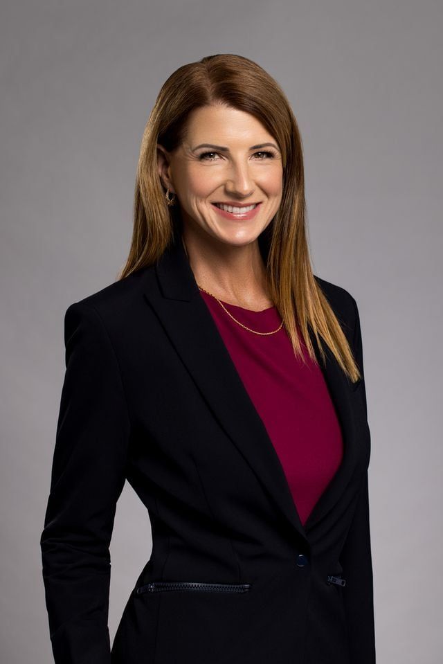 Suzanne Hobbs, head and shoulders, against a grey background.